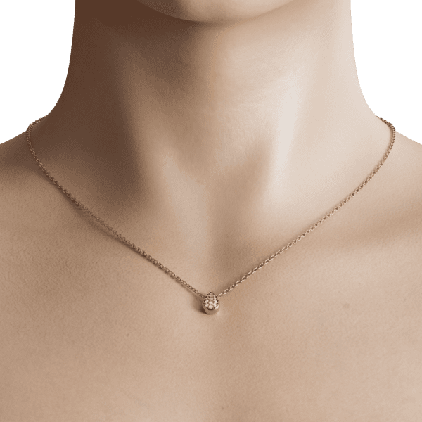 The small round shape of the pendant adds a touch of elegance and sophistication, while its compact size makes it easy to wear alone or layered with other necklaces. The gold tone is warm and inviting, complementing a variety of skin tones and personal styles.