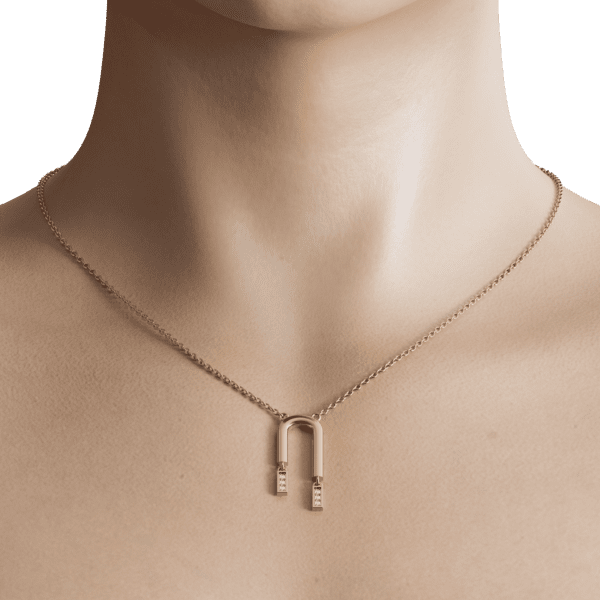 The clean lines and minimalist aesthetic of this piece make it easy to pair with any outfit, from casual weekend attire to business attire. The subtle curve of the U-shape adds a touch of whimsy, making it a great conversation starter.